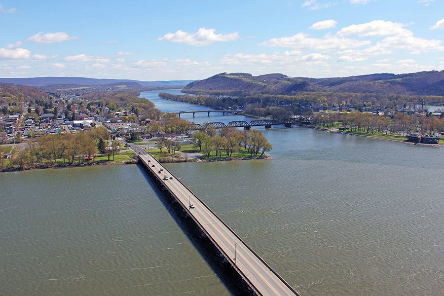 Contact - Aerial View of Rural Town with Trees and Susquehanna River in the Background